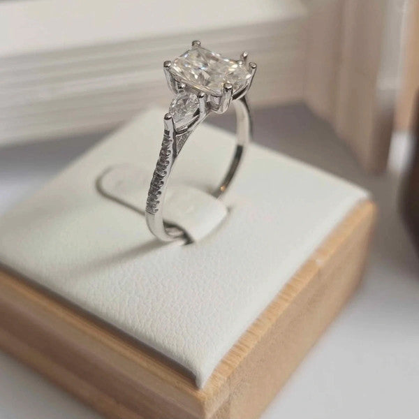 Silver ring with a large diamond on a wooden stand