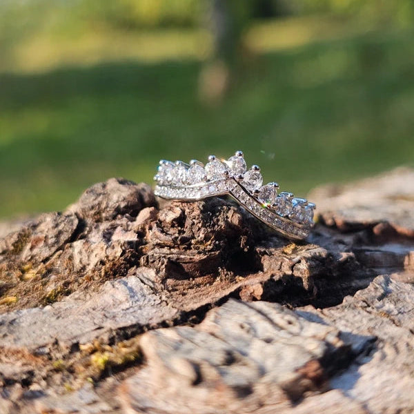 Diamond ring on a wooden surface with a blurred natural background