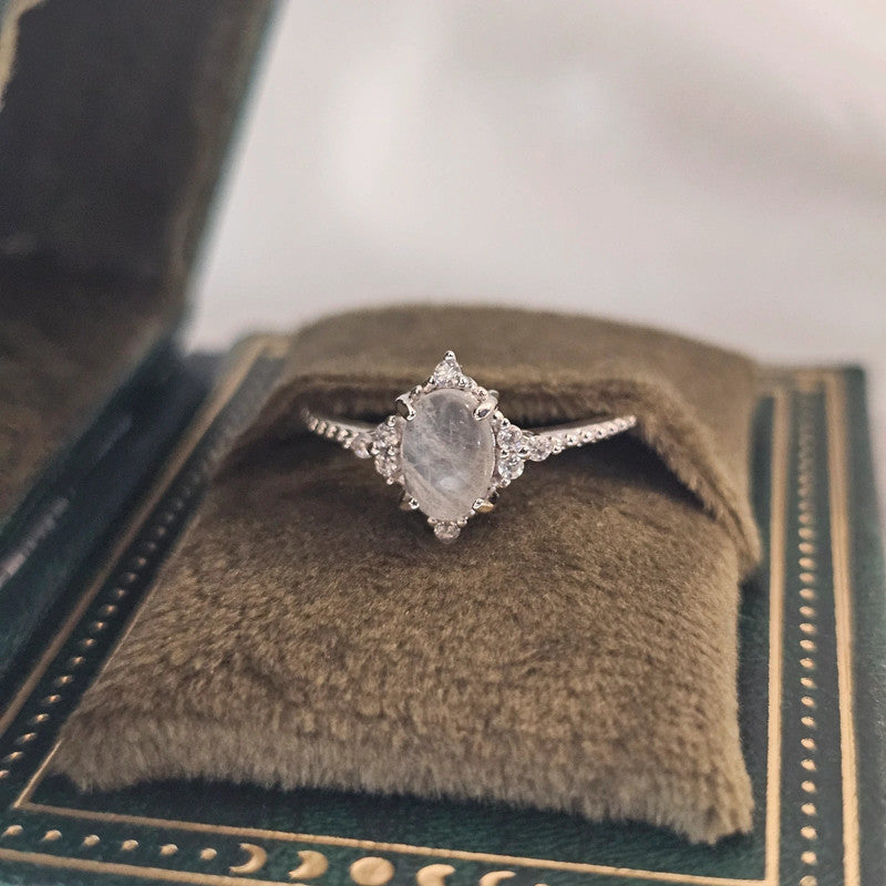 natural moonstone ring sat in green celestial book-style box