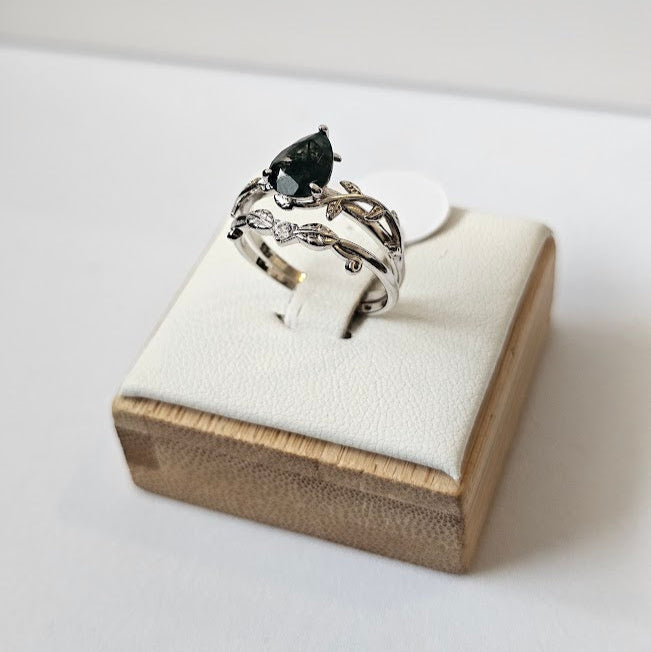 Moss agate and cubic zirconia ring displayed on white cushion over wooden box