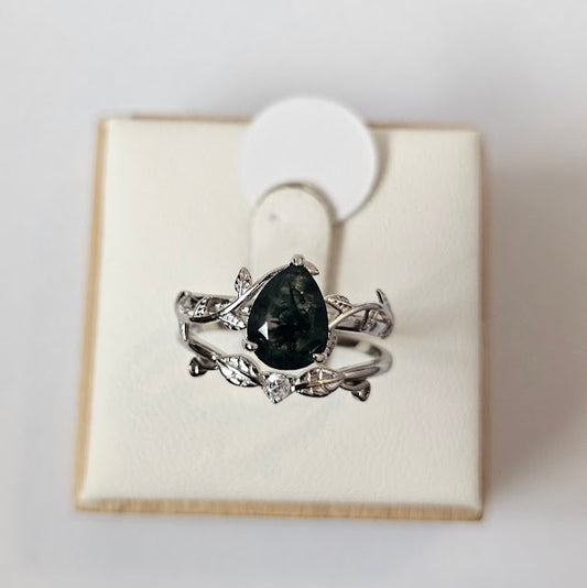 Natural moss agate ring with cubic zirconia accents and leaf-detail band displayed on a ring box