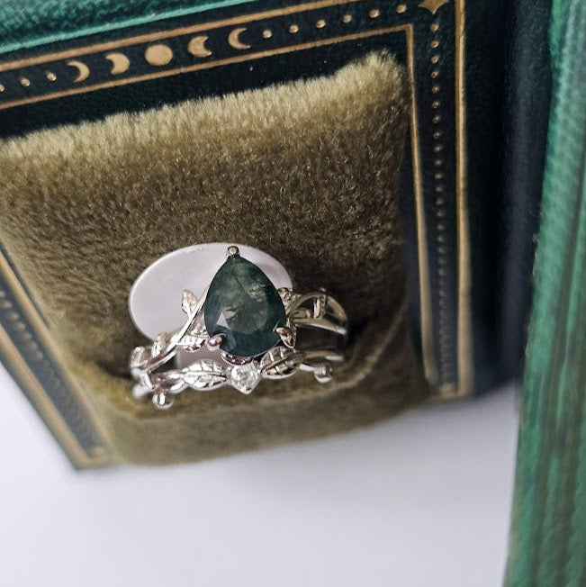Moss agate and cubic zirconia ring displayed inside vintage green jewelry box with decorative moon pattern