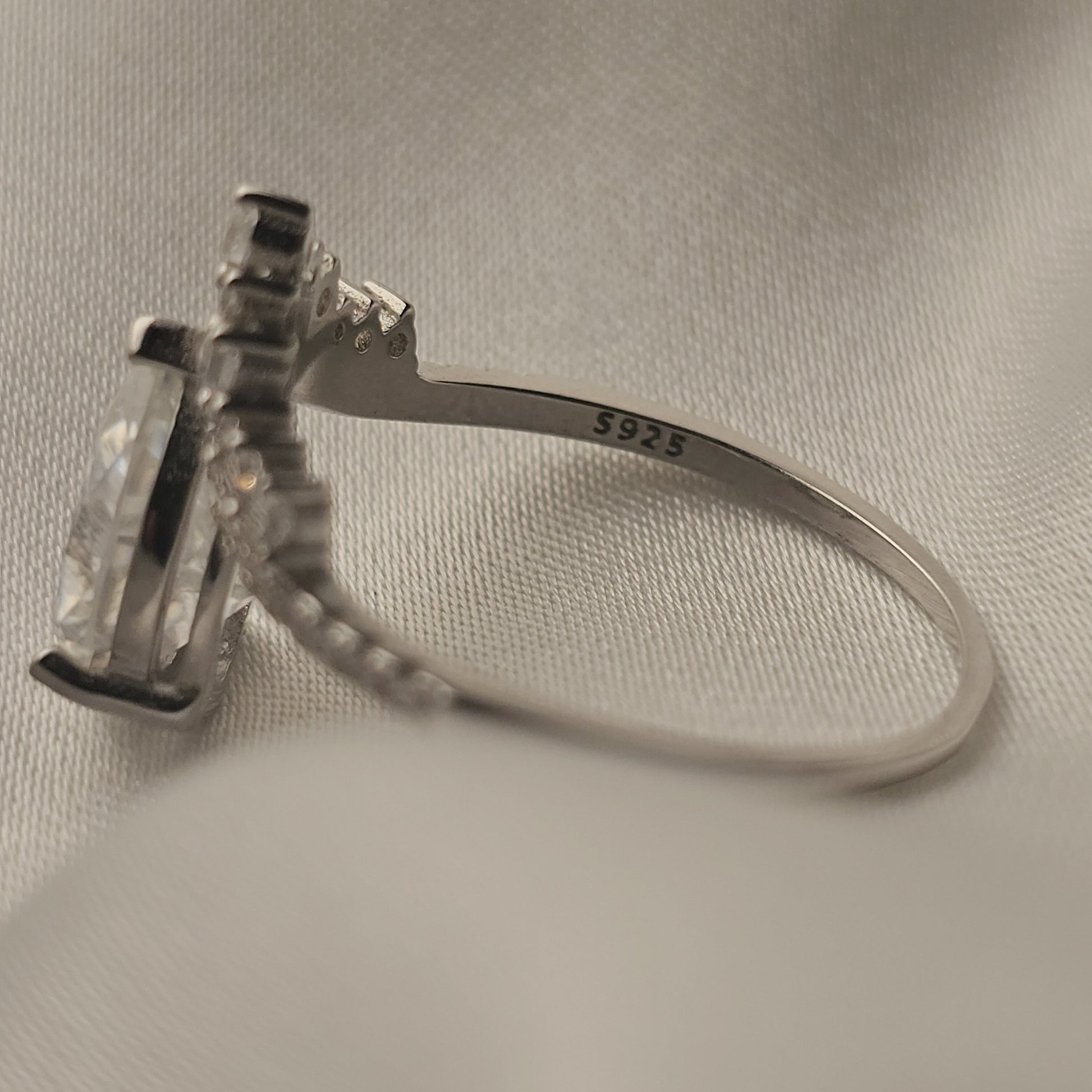 Silver ring with diamond on a light fabric background