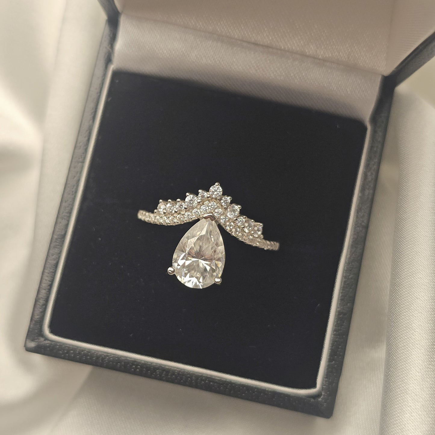 Diamond ring in a black jewelry box on a white fabric background