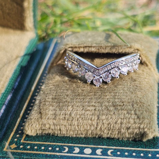 Diamond ring on a textured green cushion with a natural background