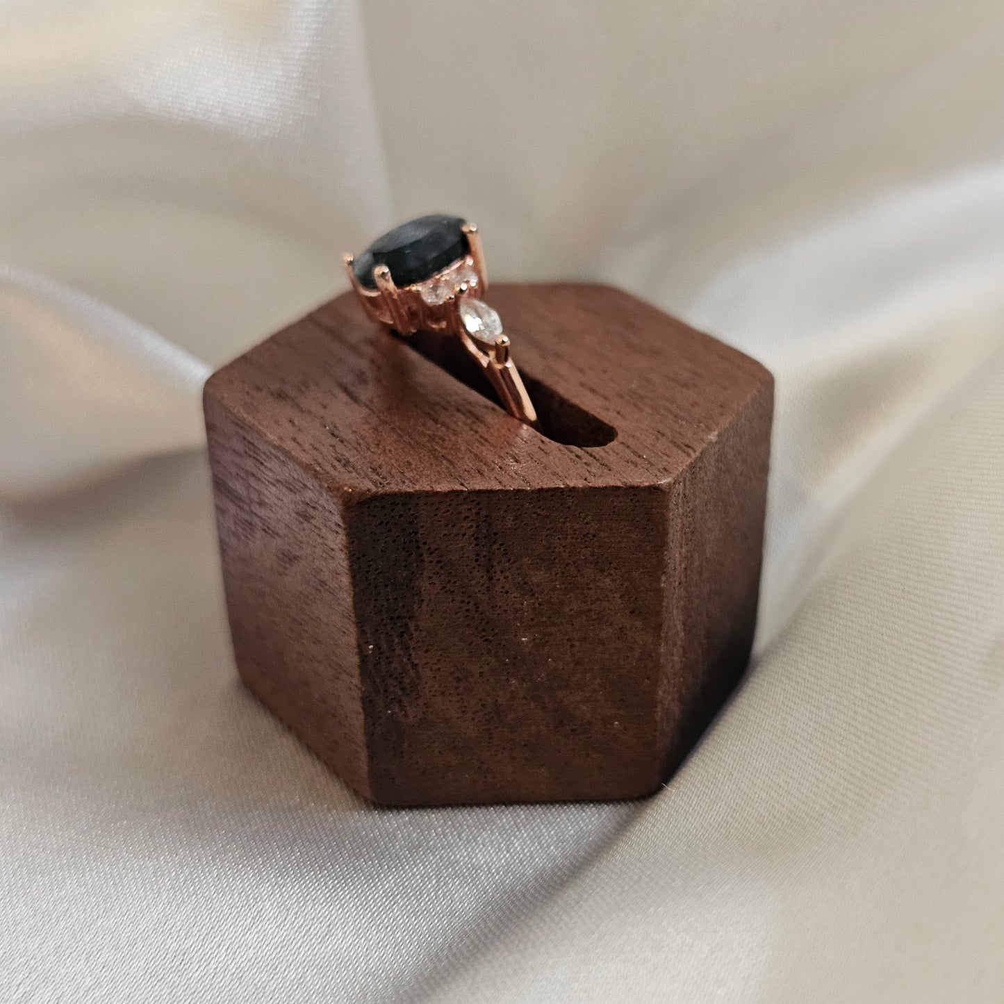 Ring with a black gemstone in a wooden box on a light fabric background