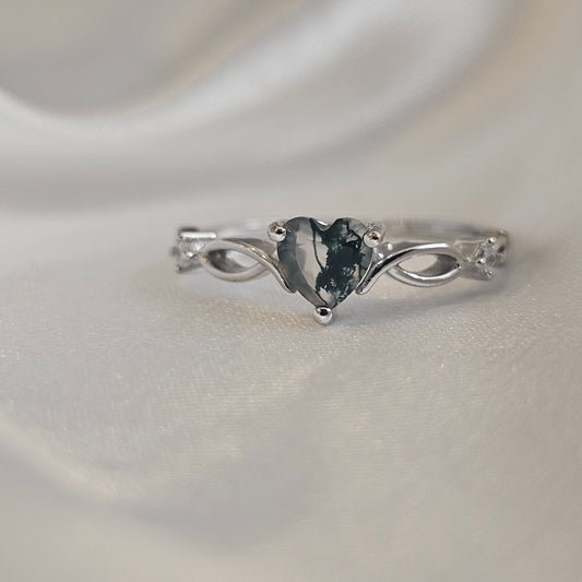 Natural Moss Agate heart-cut gemstone ring in sterling silver with infinity design — Evergreen Heart Ring on satin background.