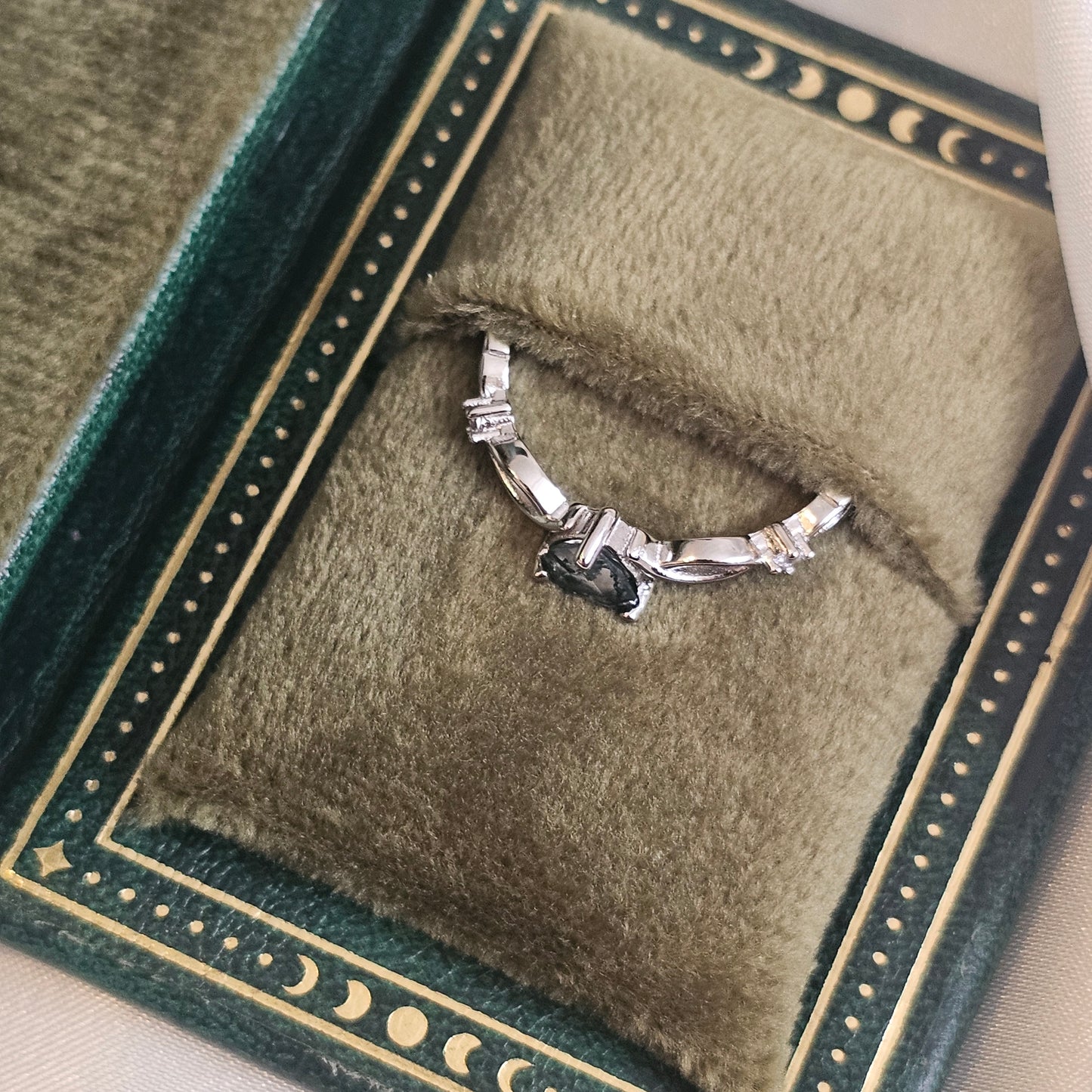 Evergreen Heart Ring — natural heart-cut Moss Agate solitaire in 925 sterling silver with infinity band, displayed in green velvet jewellery box.