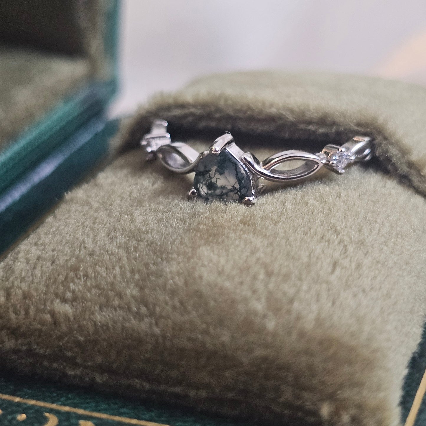 Evergreen Heart Ring — natural heart-cut Moss Agate solitaire in 925 sterling silver with infinity band, displayed in green velvet jewellery box.
