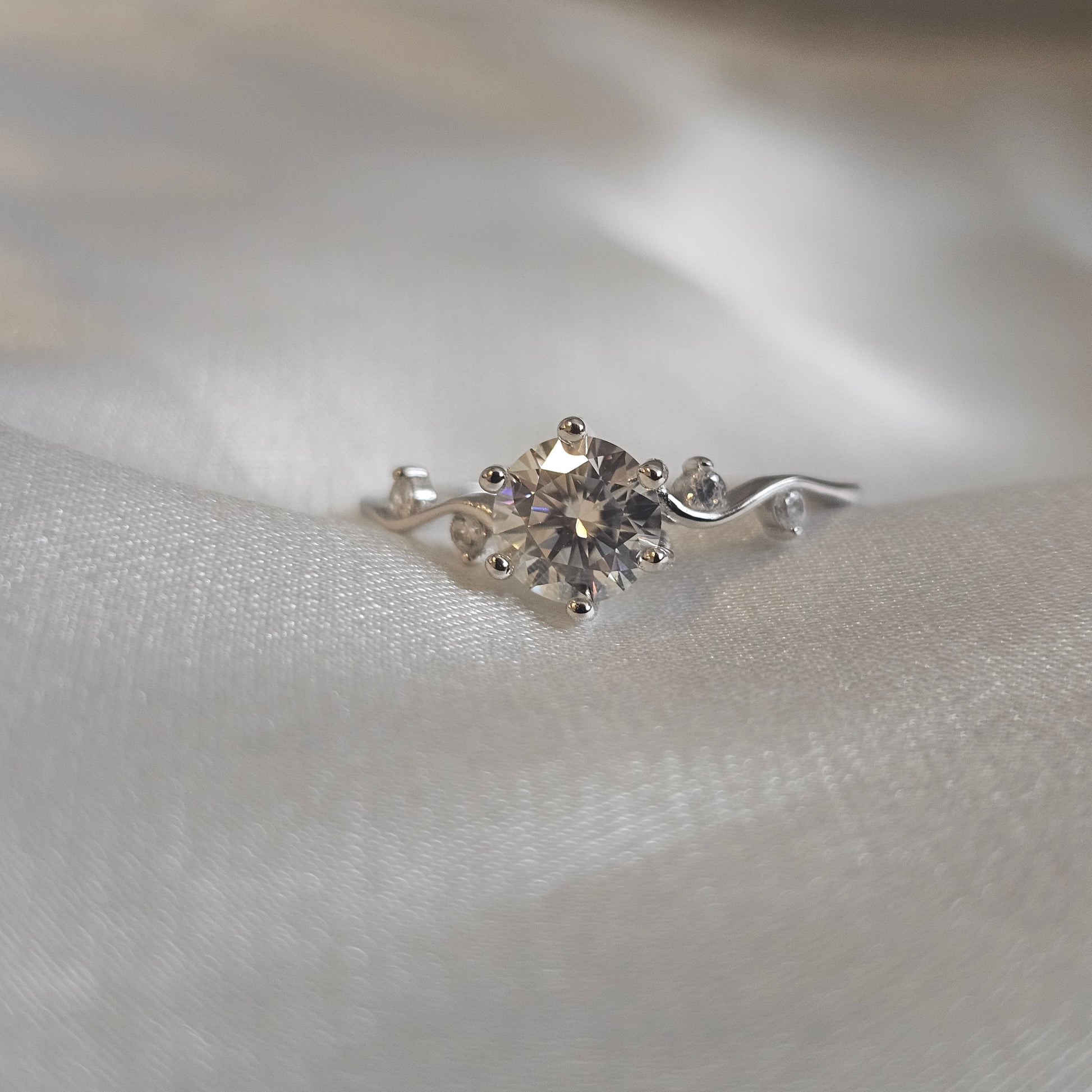 diamond moissanite ring on white silk background