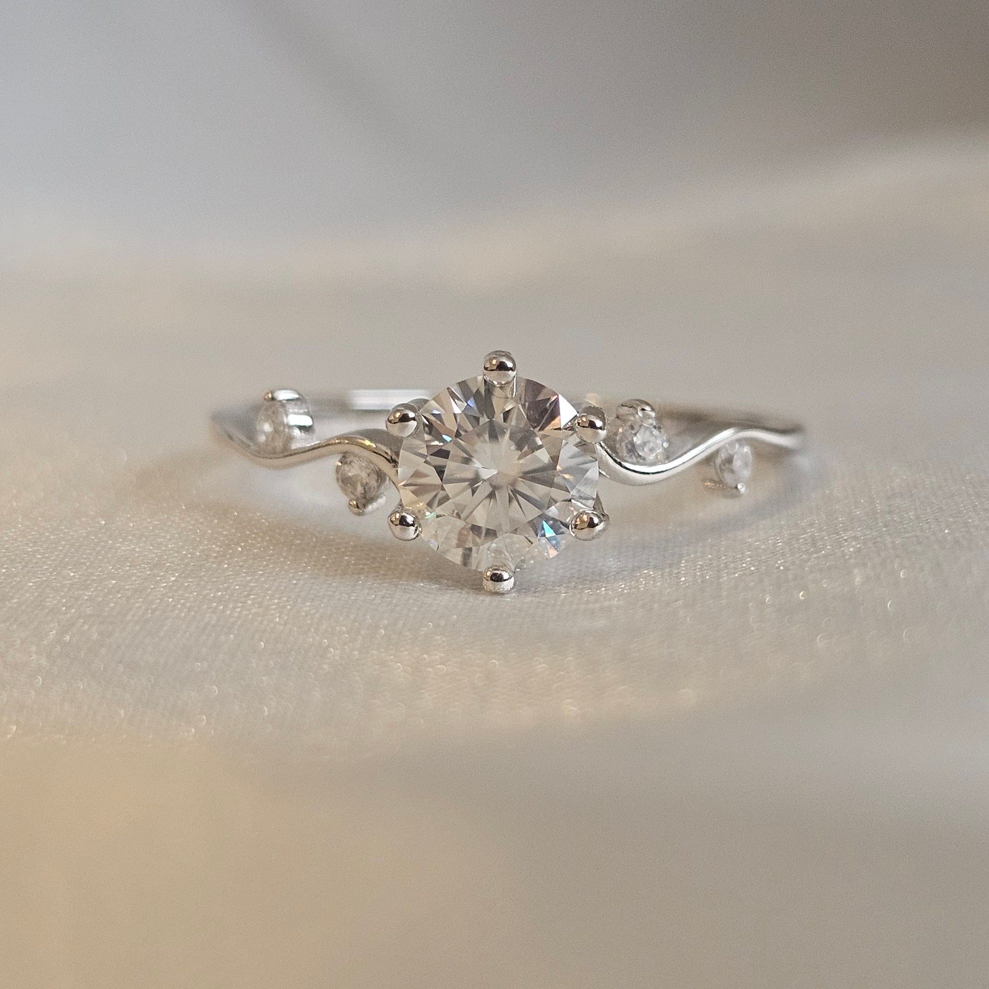 Silver ring with a 1ct moissanite diamond gemstone on a neutral background