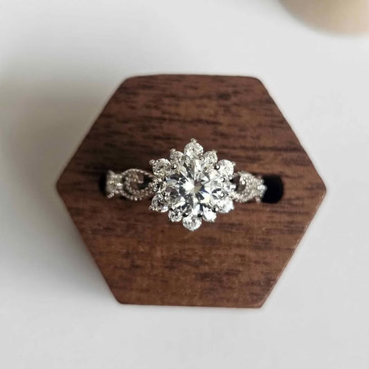 Moissanite flower halo ring with cluster of marquise stones displayed on hexagonal wooden stand