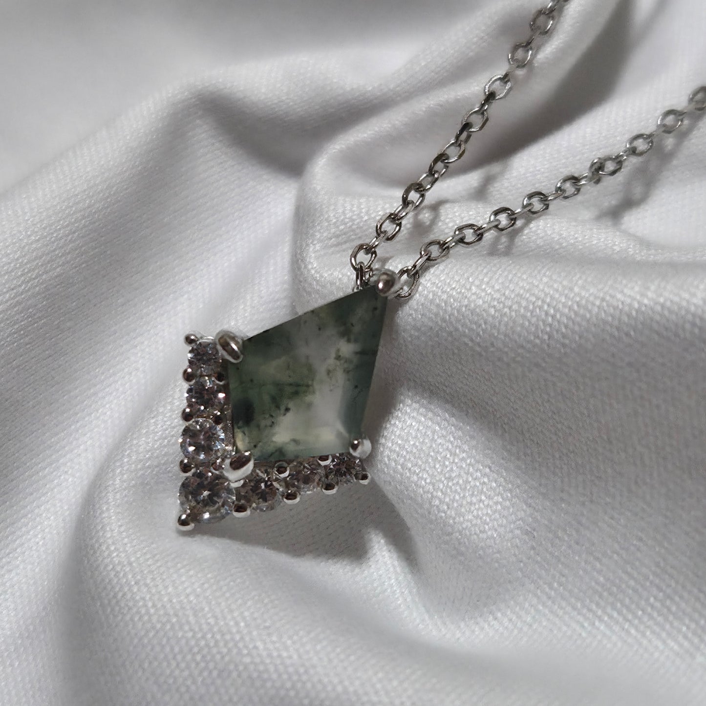 Necklace with a triangular pendant on a white fabric background