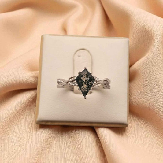 Kite cut Moss Agate ring in 925 silver with 18k white gold plating, forest-inspired gemstone jewellery with cubic zirconia accents, displayed in a cream ring box on soft fabric background