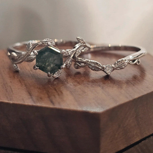 Silver moss agate bridal ring set on a wooden surface