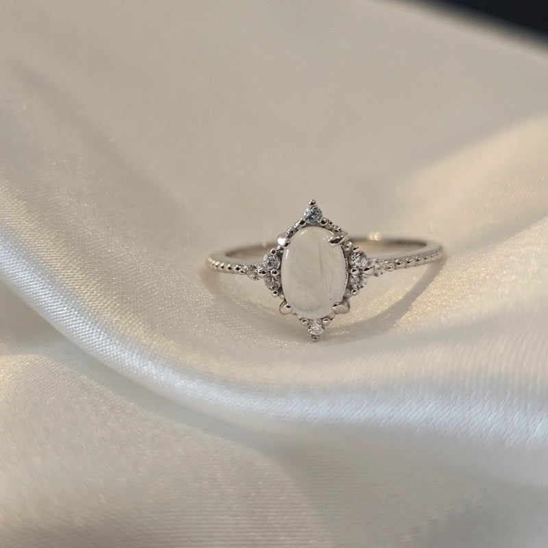 Silver ring with gemstones on a light fabric background