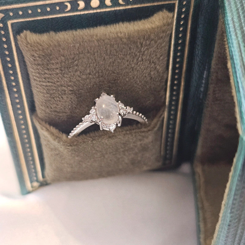 natural moonstone ring sat in green celestial book-style box