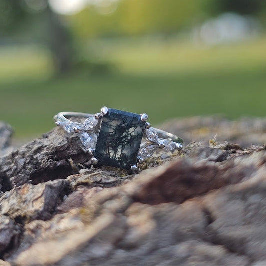 Moss agate ring emerald cut stone natural 925 silver on a woodland backdrop 