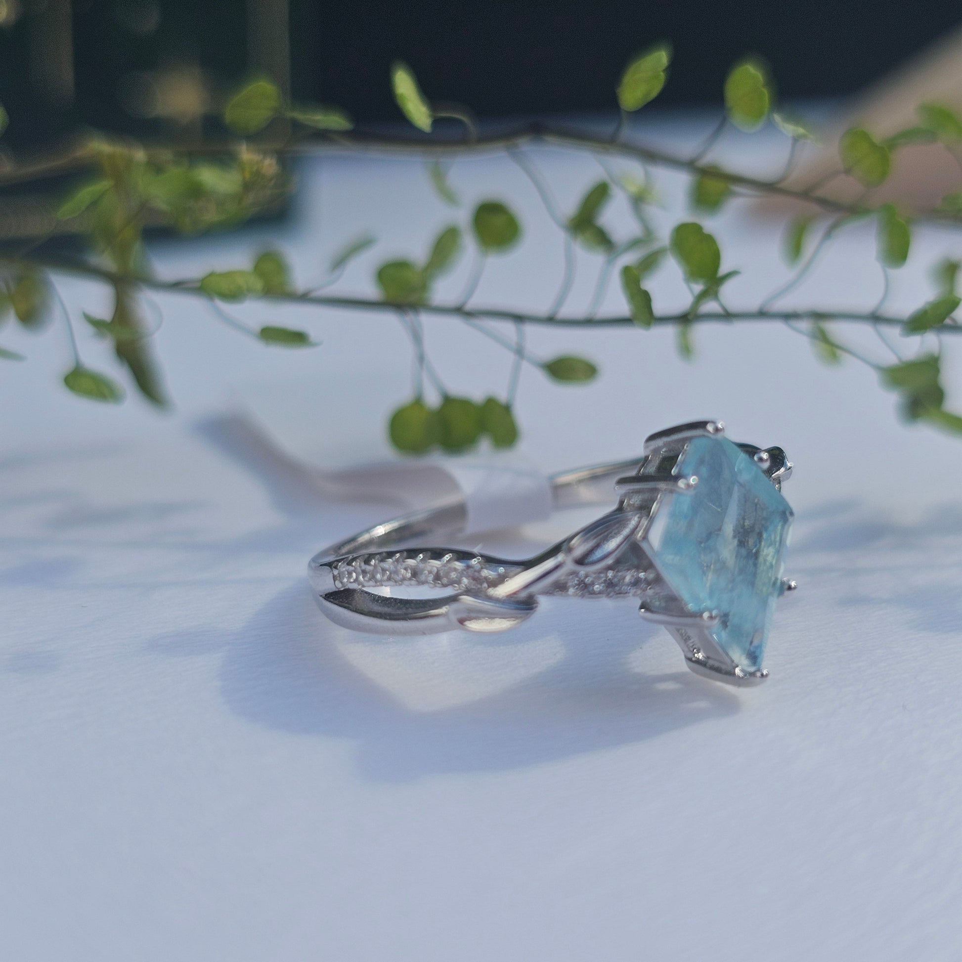 Silver ring with a blue gemstone on a light background