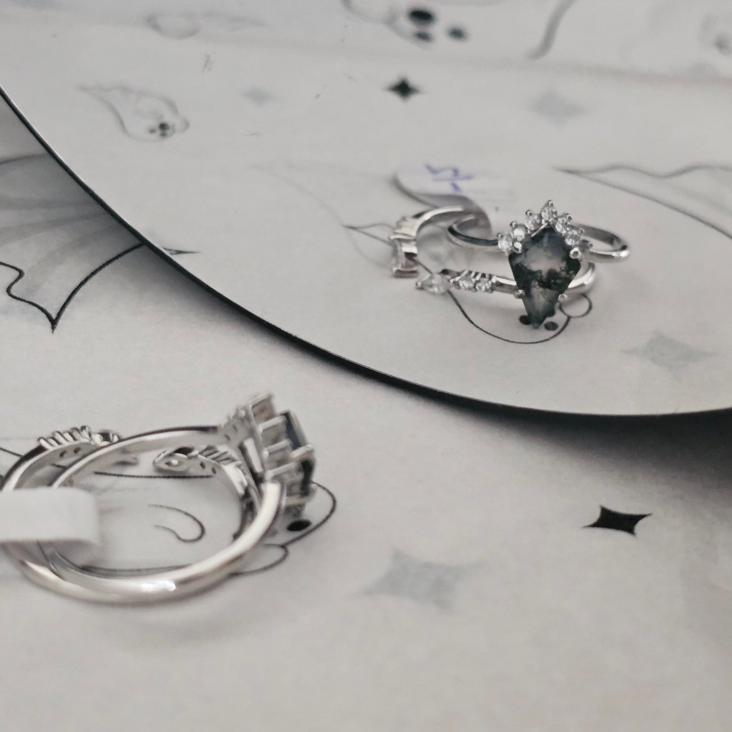 moss agate stacking ring set on white Halloween surface reflecting into a mirror
