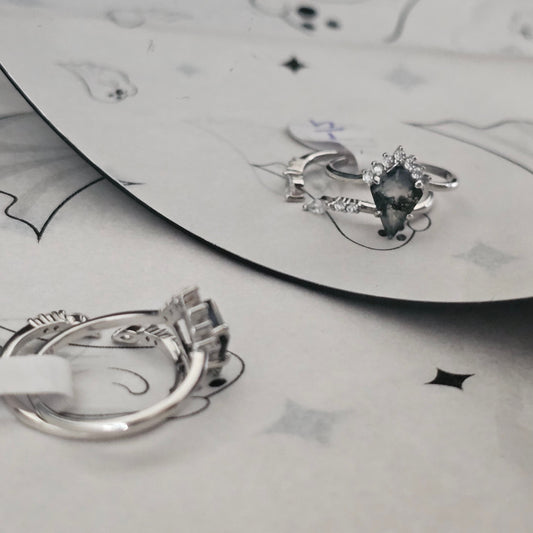 moss agate stacking ring set on white Halloween surface reflecting into a mirror