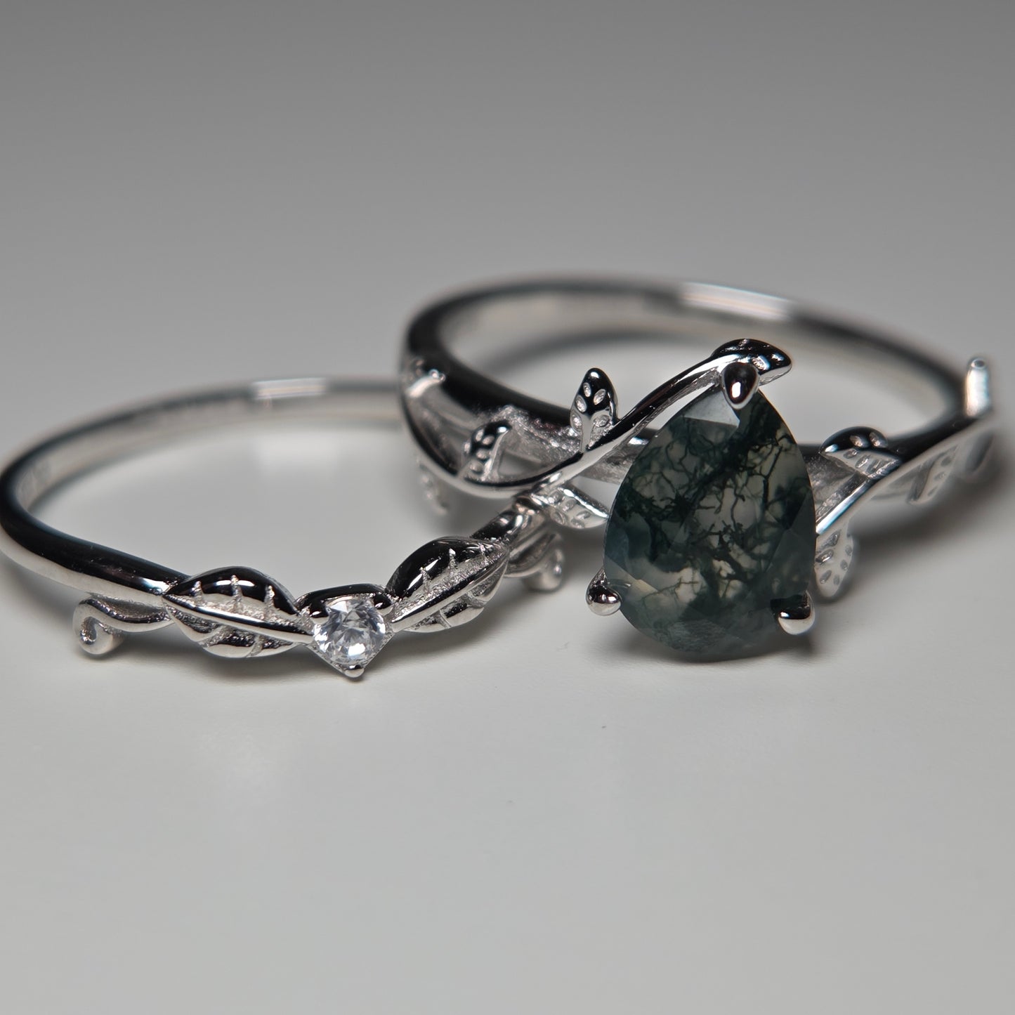 Silver ring with a dark gemstone on a gray background