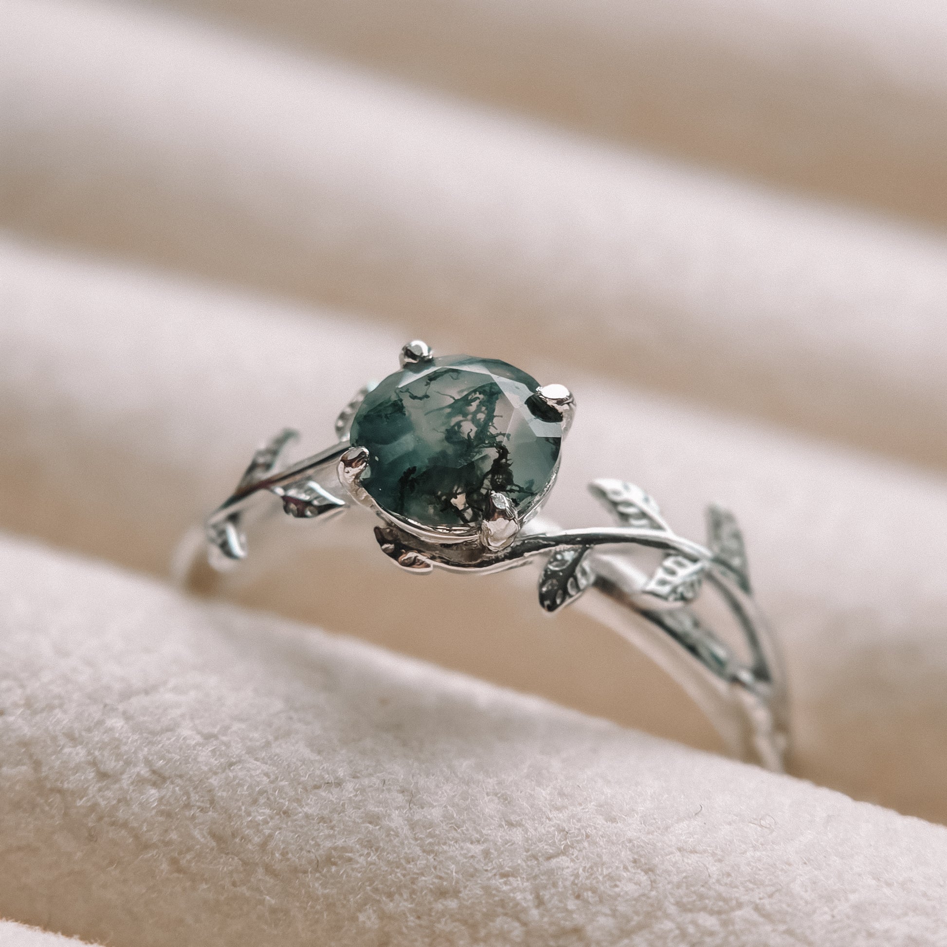 Silver ring with a green NATURAL MOSS AGATE gemstone on a soft beige background