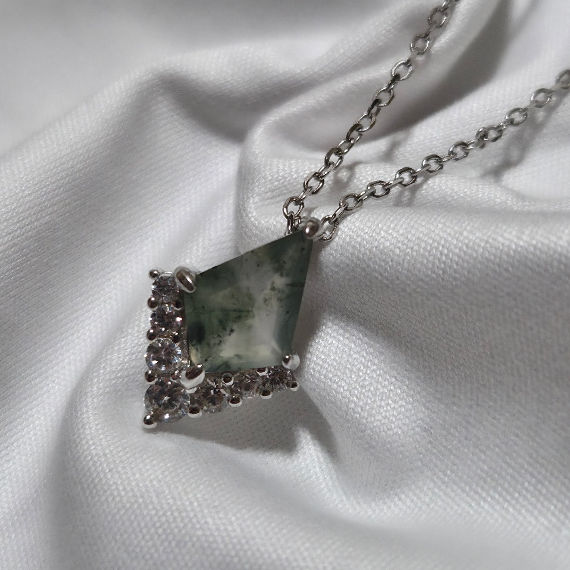 Necklace with a triangular pendant on a white fabric background