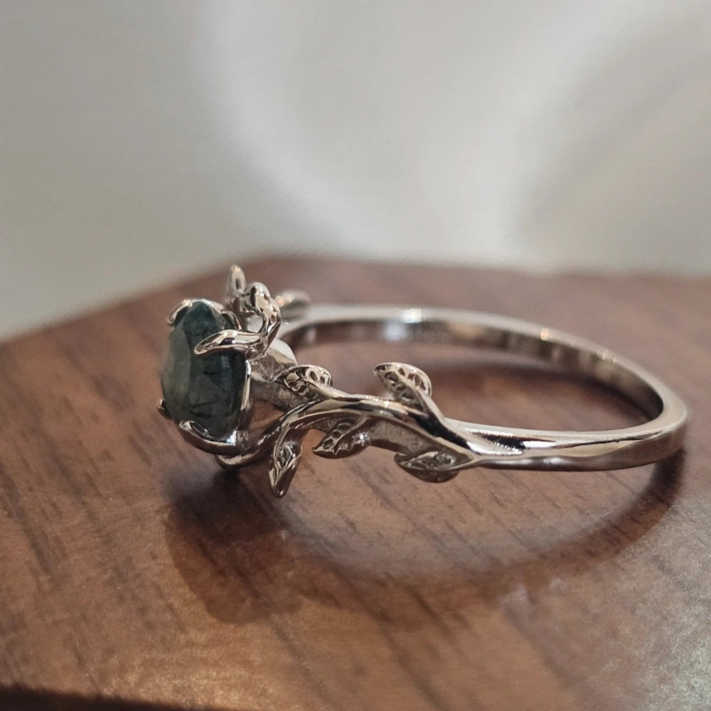 silver 925 ring with a green moss agate natural gemstone on a wooden surface